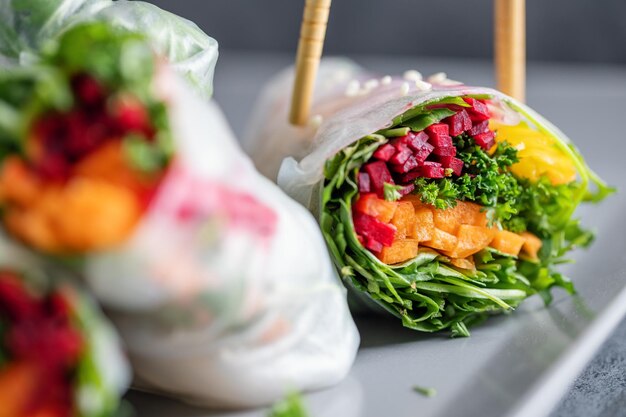 Rolos de papel de arroz vegano com legumes e gergelim servidos no prato pronto para comer