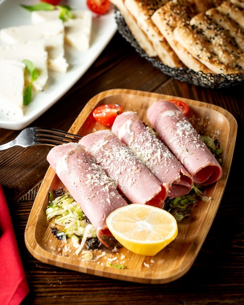 Rolos de salame, guarnecidos com parmesão e limão