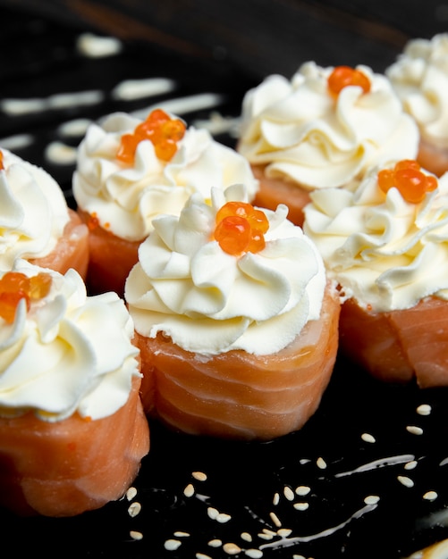 Rolos de sushi com creme e caviar vermelho por cima