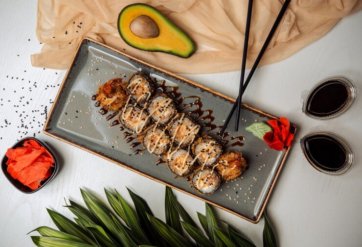 Foto grátis rolos de sushi frito, guarnecidos com gergelim, molho teryaki, servido com wasabi e gengibre