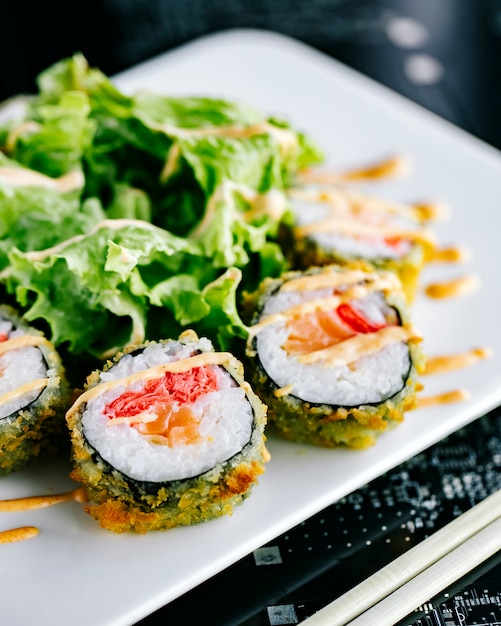 Rolos de sushi quentes com salmão e gengibre, guarnecidos com maionese picante