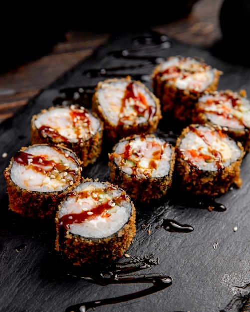 rolos de sushi servidos com molho e gergelim