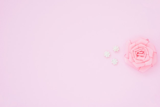 Rosa rosa feita com fita no fundo rosa com espaço para escrever o texto