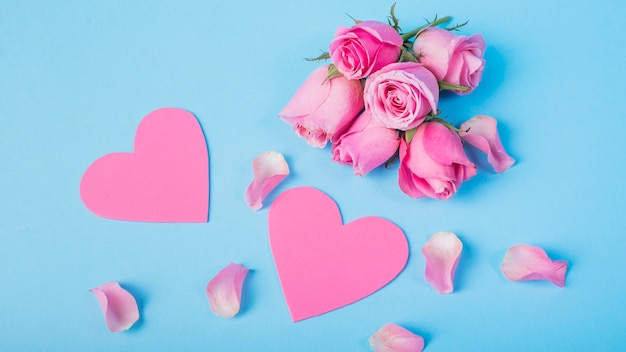 Rosas cor de rosa com corações na mesa