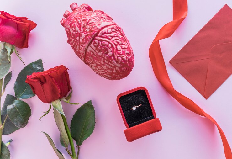Foto grátis rosas vermelhas com anel de casamento na mesa