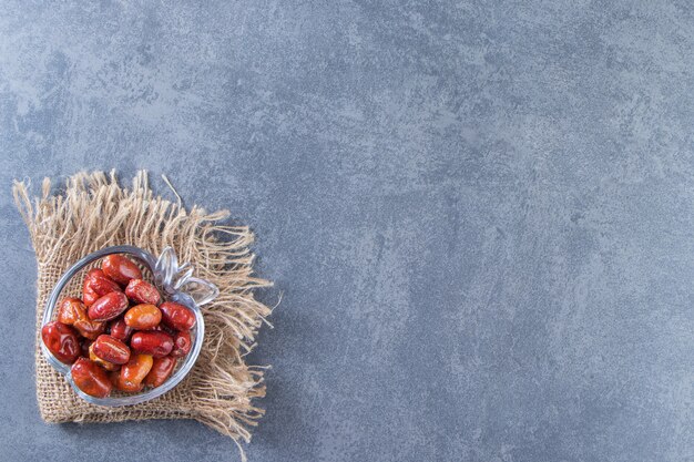 Rosehips em uma tigela de vidro na textura, no fundo de mármore.