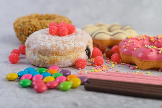 Rosquinhas polvilhadas com açúcar e doces em uma superfície branca.