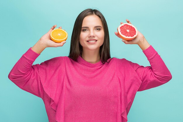 Rosto de mulher bonita com deliciosas laranja e grapefruit em estúdio