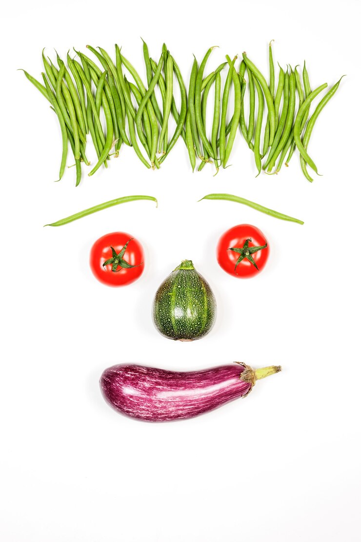 Foto grátis rosto feliz vertical com vegetais no fundo branco