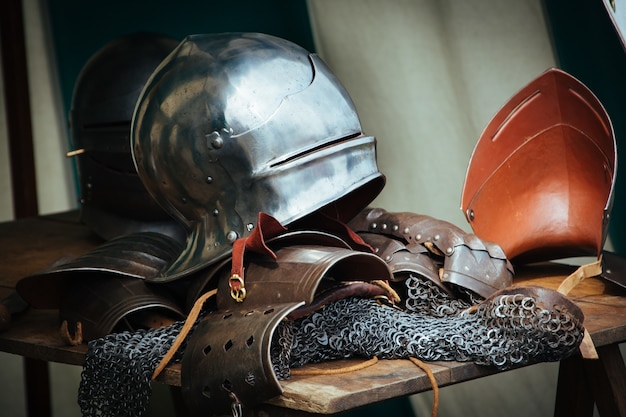 Roupas e ferramentas de um cavaleiro medieval na mesa