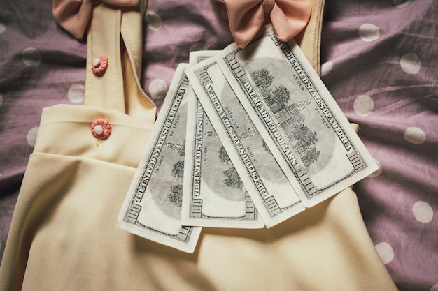 Roupas femininas combinadas com notas de dólar.