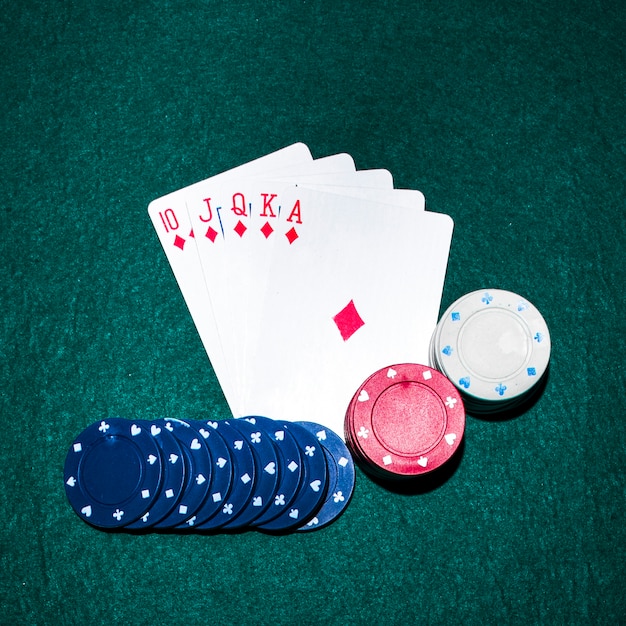 Royal flush baralho e fichas de casino em fundo verde poker