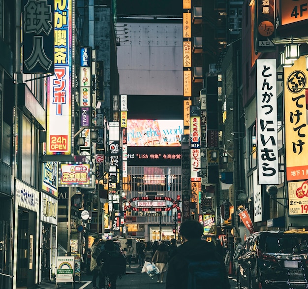 Rua movimentada da cidade à noite com pessoas e placas