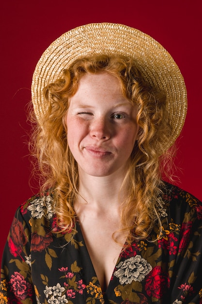 Foto grátis ruiva jovem fêmea piscando e olhando para a câmera