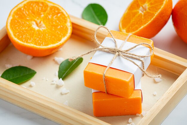Sabonete laranja com laranja fresca sobre fundo de mármore