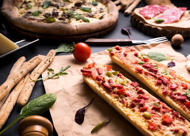 Foto grátis saborosa comida italiana com tomate cereja; varas de pão e garfo