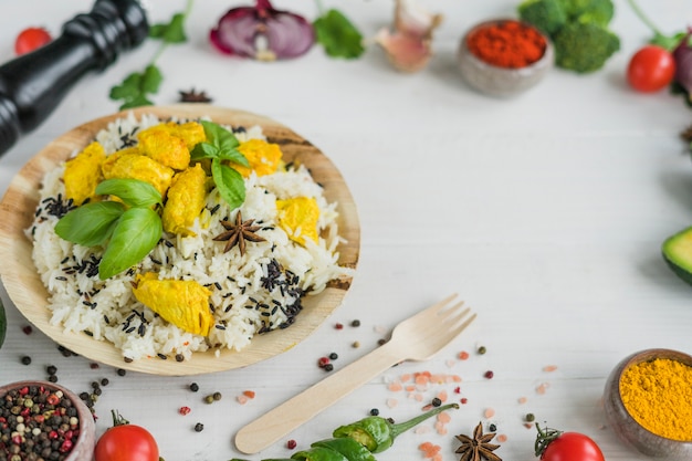 Saborosa comida na placa circular com especiarias e vegetais na superfície branca