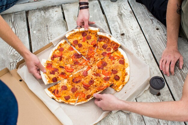 Saborosa pizza na caixa na superfície de madeira