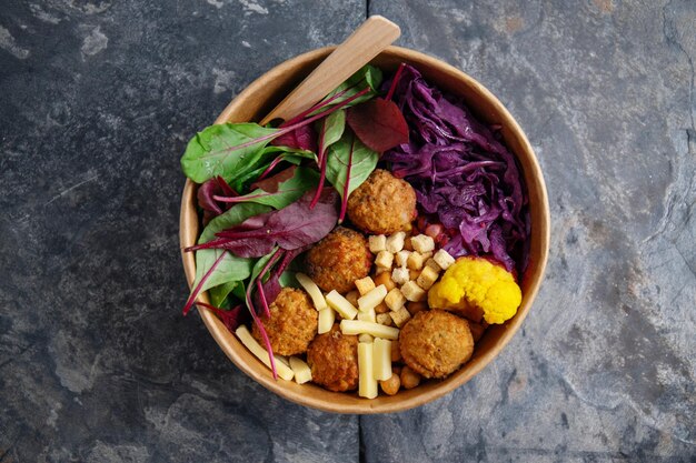 Saborosa salada vegetariana vegana com falafel de grão de bico e folhas servidas em tigela de papel Vida saudável ou conceito de desperdício zero