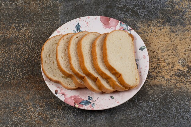 Saborosas fatias de pão branco em prato colorido