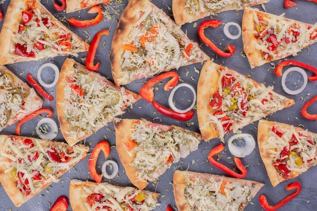 Saborosas fatias de pizza em azul com anéis de cebola e pimenta.