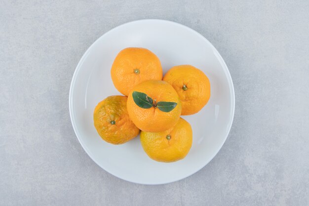 Saborosas tangerinas frescas em prato branco