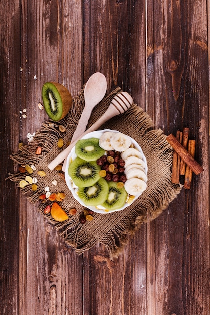 Saboroso café da manhã saudável feito de leite e mingau com nozes, kiwis e mel