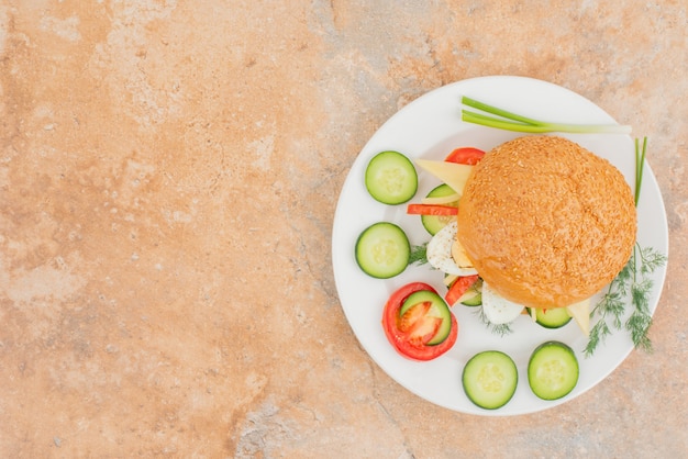 Saboroso hambúrguer com rodelas de pepino e tomate