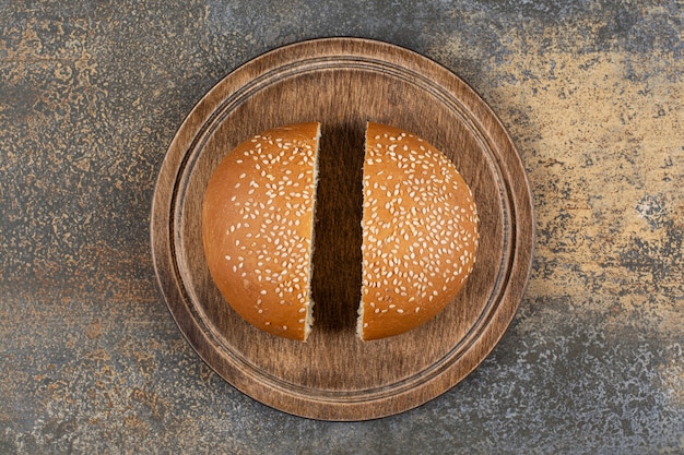 Foto grátis saboroso pão com sementes de gergelim na placa de madeira.