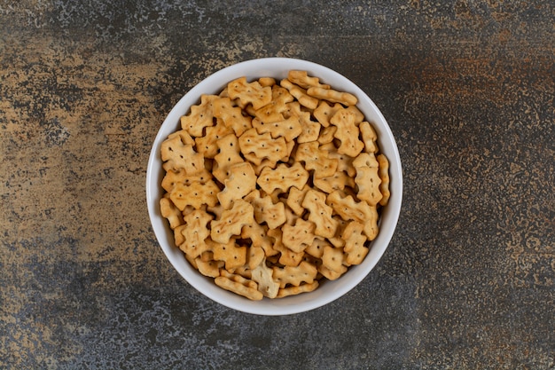 Saborosos biscoitos assados em uma tigela branca.