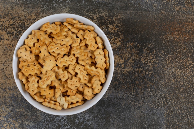 Saborosos biscoitos assados em uma tigela branca.