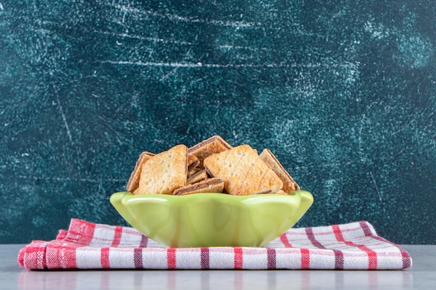 Foto grátis saborosos biscoitos com recheio de chocolate em uma tigela verde.