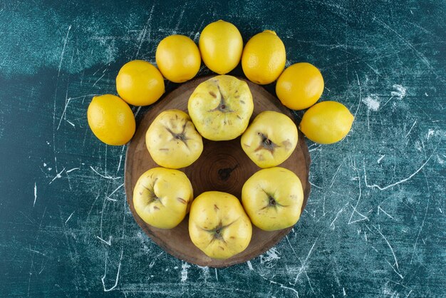 Saborosos marmelos e limões na mesa de mármore.