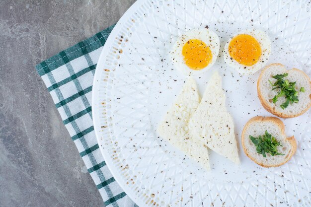 Saborosos ovos cozidos com especiarias e pão na toalha de mesa. foto de alta qualidade