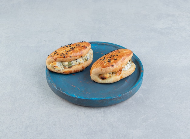 Foto grátis saborosos pastéis recheados com queijo na placa azul.