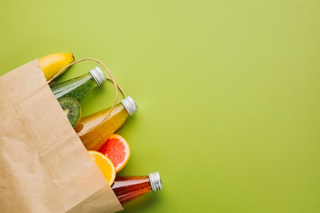 Foto grátis saco de papel flatlay com frutas e sucos