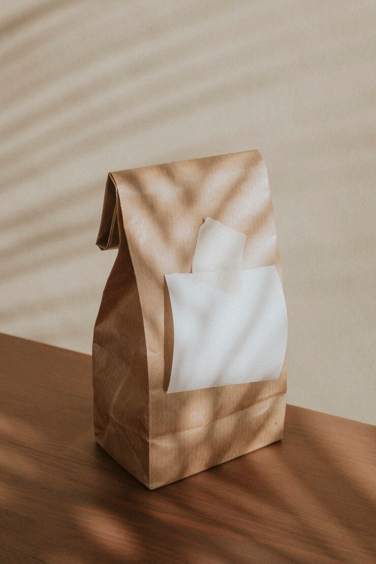 Foto grátis saco de papel marrom com um papel branco em branco