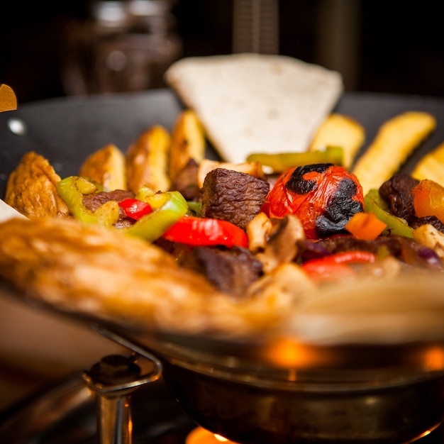 Foto grátis saco de vista lateral com carne e batatas fritaslavash na mesa no restaurante