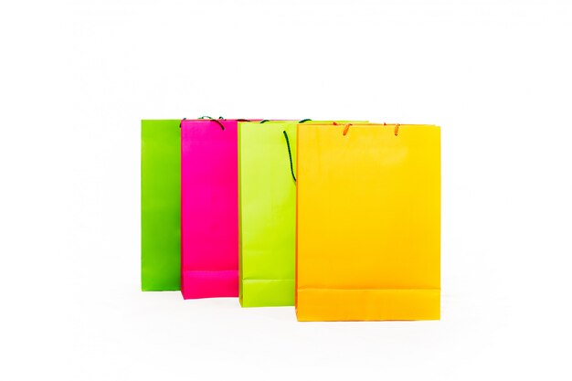 Sacolas coloridas sortidas, incluindo amarelo, laranja, rosa e verde sobre fundo branco