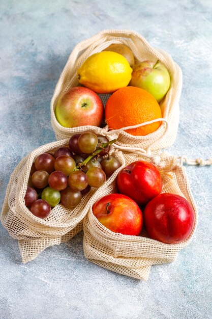 Sacolas de compras de algodão bege simples e ecológicas para comprar frutas e verduras com frutas de verão.