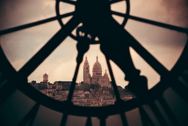 Sacre-Coeur visto através da torre do relógio gigante em Paris, França.