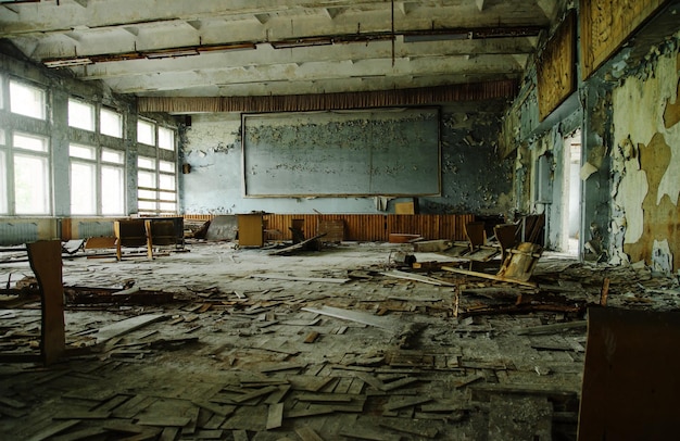 Sala de aula da escola abandonada na zona da cidade de Chernobyl da cidade fantasma de radioatividade