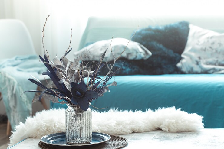 Foto grátis sala de estar moderna, com flores artificiais em um vaso e itens de decoração para casa em mesa de luz de madeira.