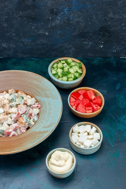 Salada à base de maionese com vegetais frescos fatiados em azul escuro