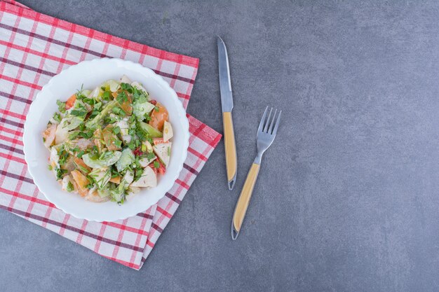 Salada com legumes picados e ervas na superfície azul