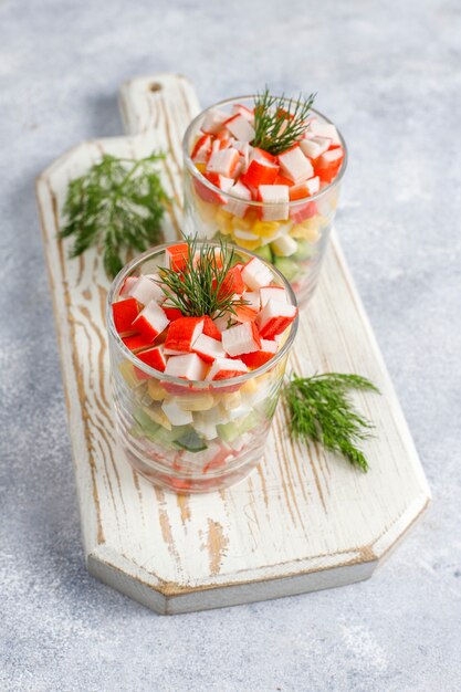Salada com palitos de caranguejo, ovos, milho e pepino.