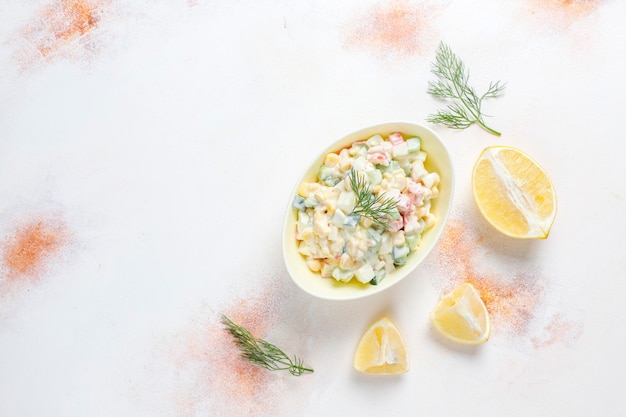 Salada com palitos de caranguejo, ovos, milho e pepino.