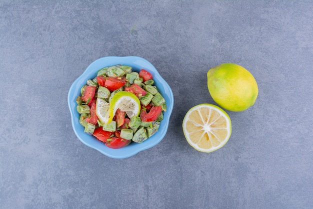 Salada com tomate picado e feijão verde servido com limão