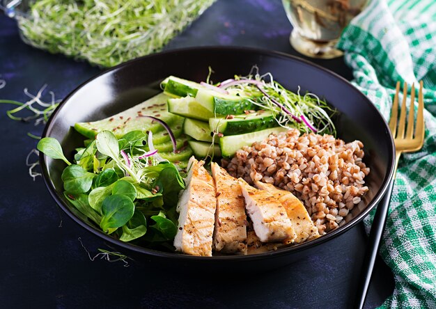 Salada de almoço. Tigela de Buda com mingau de trigo sarraceno, filé de frango grelhado, salada de milho, microgreens e daikon. Comida saudável.