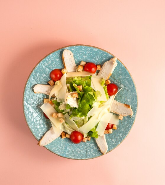 salada de caesar com frango grelhado tomate cereja parmesão alface e rusk no prato